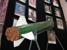 A Qassam rocket is displayed in Sderot town hall against a background of pictures of residents killed in rocket attacks